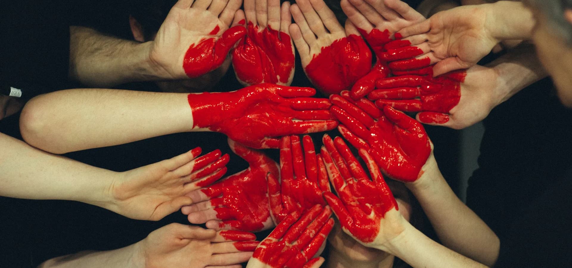 Community members joining hands around a painted heart
