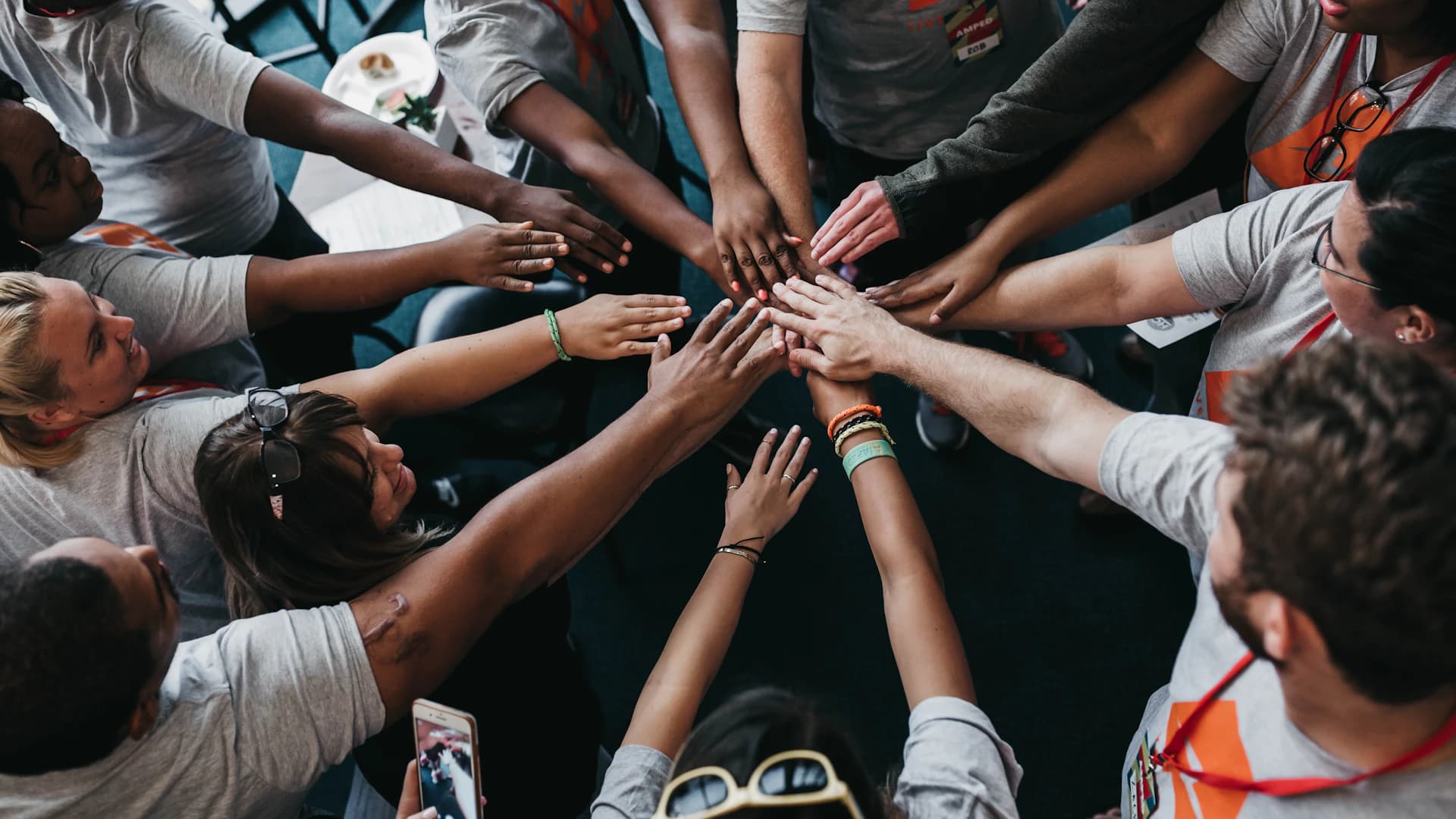 A team joining hands to represent shared purpose and collaboration
